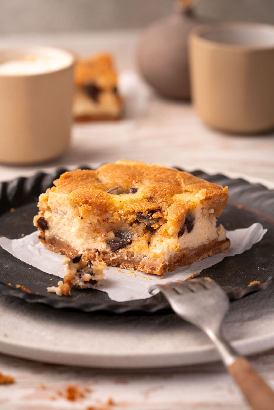 Cookie Dough Cheesecake Schnitten. Fudgy Teig mit Chocolate Chunks trifft auf cremigen Käsekuchen. Einfaches Rezept für himmlischen Genuss!