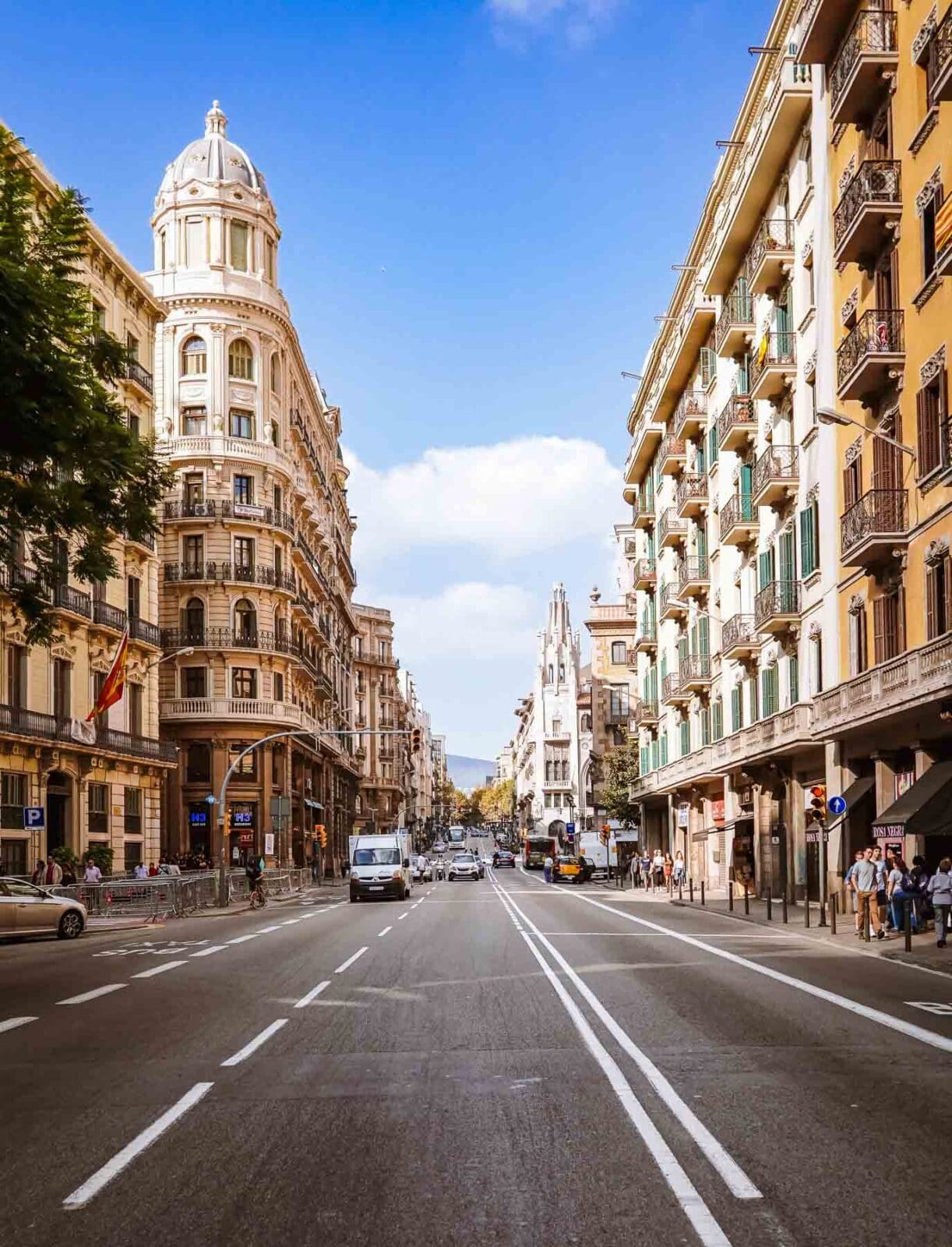 Breite Straße mit Altbauten und Kuppelturm in Barcelona