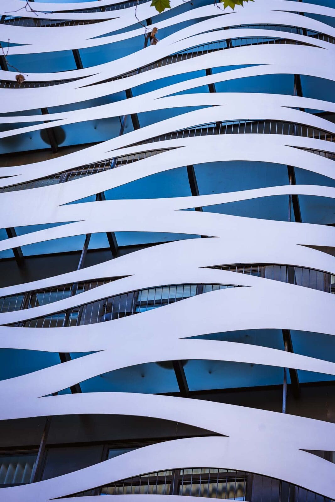 Geschwungene weiße Fassade eines modernen Gebäudes im Eixample, Barcelona