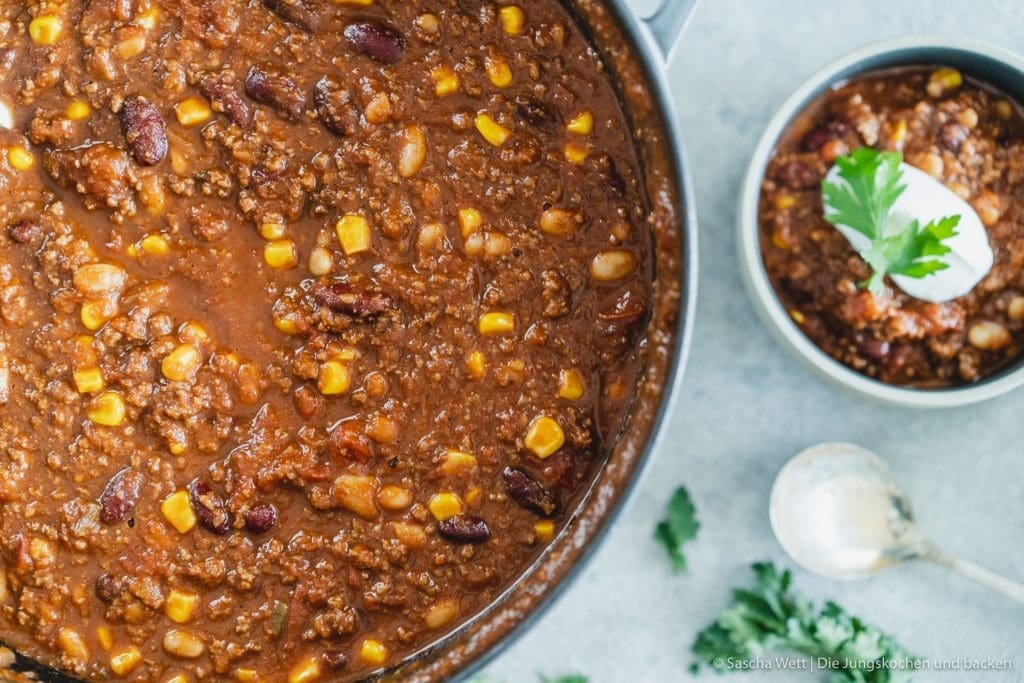 Chili con carne 4 Chili Con Carne 5 | Torsten und ich haben Anfang des Monats unsere Geburtstage nachgefeiert. Da wir aber nur ein paar Tage vorher aus dem Urlaub zurückgekommen sind, war nicht wirklich viel Zeit für riesige Vorbereitungen. Daher haben wir auf einen Partyfood-Klassiker schlechthin zurückgegriffen - ein leckeres Chili con carne! Denn ein geniales Chili lässt sich in riesigen Mengen und mit super wenig Vorbereitung zubereiten - eigentlich macht es sich fast von alleine. Trotzdem hat wahrscheinlich jeder ein etwas anderes Rezept für sein Chili con carne zur Hand. In unsere Version kommen 1-2, für unsere Freunde, unwahrscheinlichen Zutaten, aber genau die machen es aus.