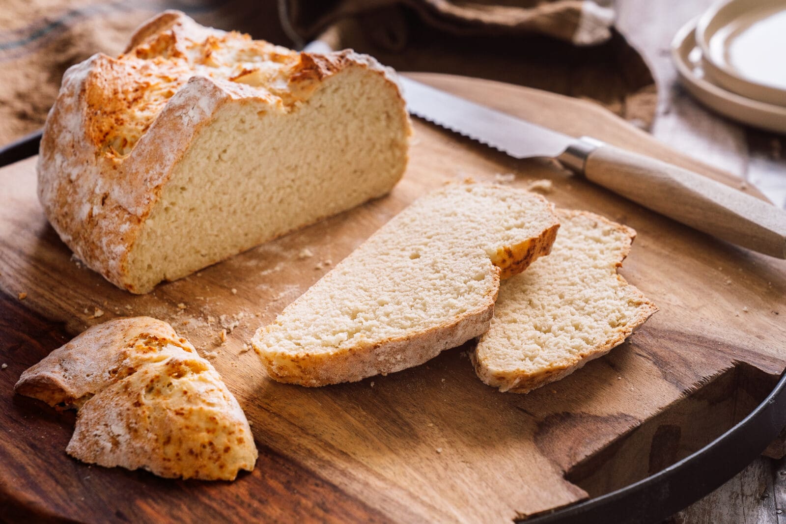 Angeschnittenes Quarkbrot mit luftiger Krume auf einem Holzbrett – schnelles Brotback-Rezept für den Alltag.