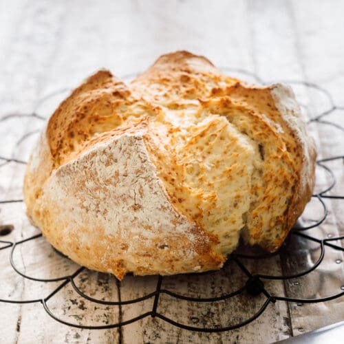 Schnelles Quarkbrot – Einfaches Rezept für ein saftiges Brot ohne Gehzeit 3 Frisch gebackenes Quarkbrot mit knuspriger Kruste auf einem Gitter – einfaches Rezept ohne Hefe und Gehzeit.