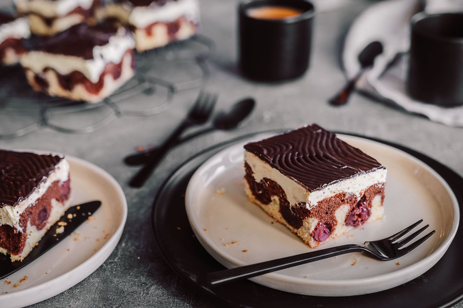 Mama Donauwelle 1 | Bei mir zu Hause heißt dieser Kuchen einfach „Monis Donauwelle“ nach meiner Mama. Der kommt immer auf den Geburtstagstisch ... saftig, süß, mit Schattenmorellen, Vanille-Puddingcreme und Schokoguss mit diesen markanten Wellen. Klingt nach ganz viel Aufwand? Keine Sorge mit etwas Planung und den richtigen Kniffen gelingt der Klassiker total entspannt. Ich verrate dir, wie du Pudding und Butter schön langsam vereinst, damit die Creme nicht gerinnt, und wie du den Schokoguss wackelig-dekorativ hinbekommst. Mehr Familienliebe auf dem Blech geht nicht.