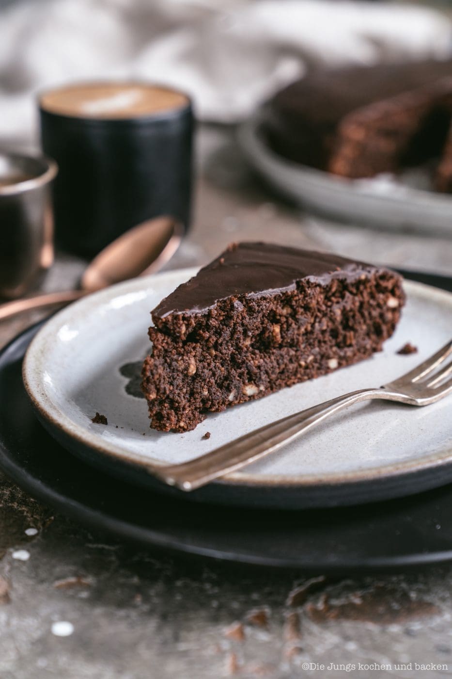 Schoko Mandel Kuchen 5 | Manche Rezepte müssen einfach in dem Glanz erstrahlen, der Ihnen gebührt. Unser super leckerer Schoko-Mandelkuchen hat in den letzten Wochen ein echtes Revival bei euch erlebt, wahrscheinlich da er ohne Mehl auskommt. Das ist ja so ein Thema aus Gründen ... Aber egal aus welchem Grund auch bei uns wandert dieser saftige Schokoladenkuchen immer wieder in den Ofen. Beim letzten Mal haben wir ihn auch noch direkt für ein Fotoshooting gebucht und Torsten hat das Rezept nochmals ein wenig verfeinert. "Aus alt mach Neu" werden wir jetzt öfters machen.