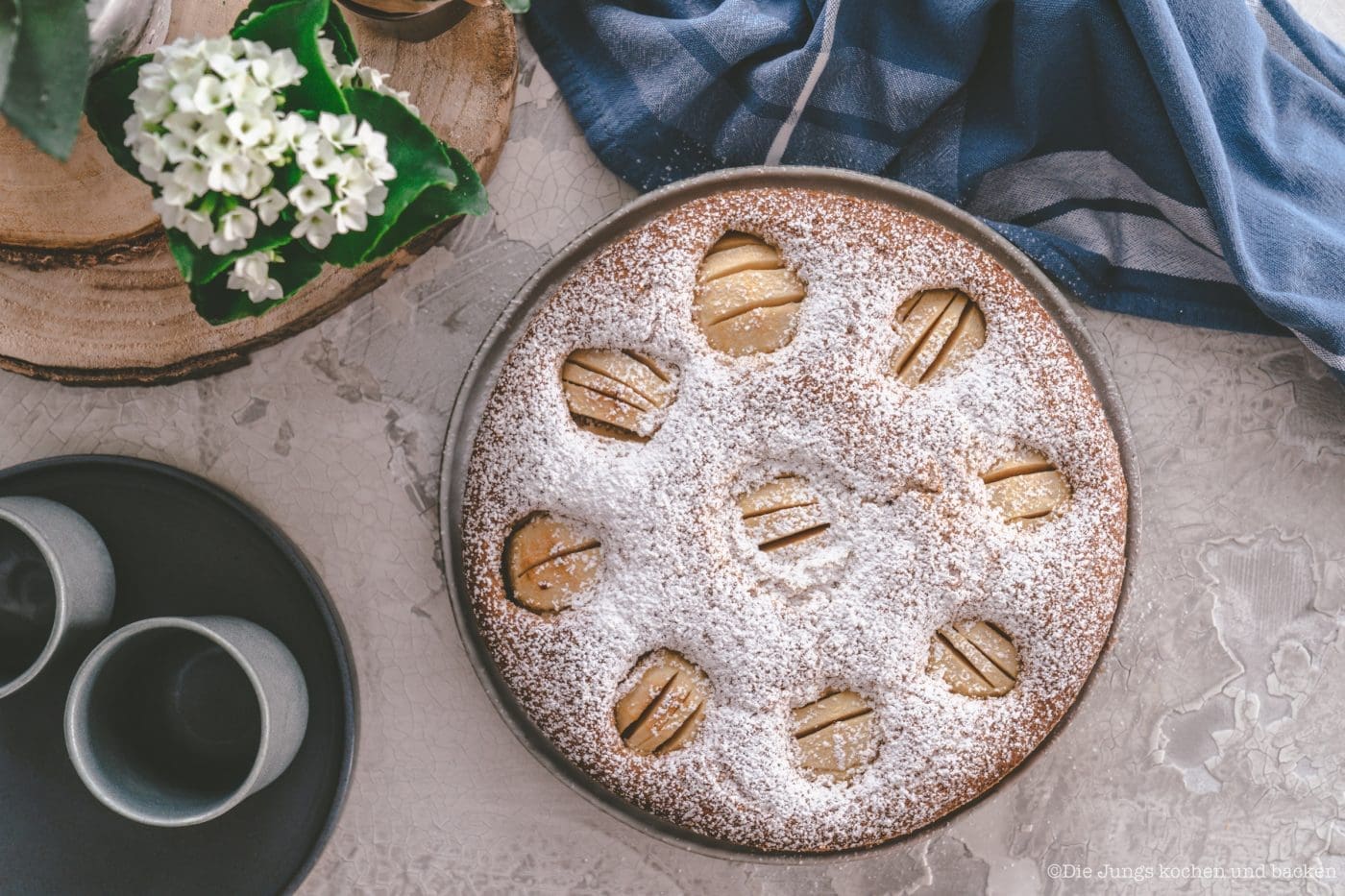 Versunkener Apfelkuchen nach Oma Lore. Saftig aus der Springform 1 Versunkener Apfelkuchen nach Oma Lore in der Springform, die Apfelhälften sind im Rührteig versunken