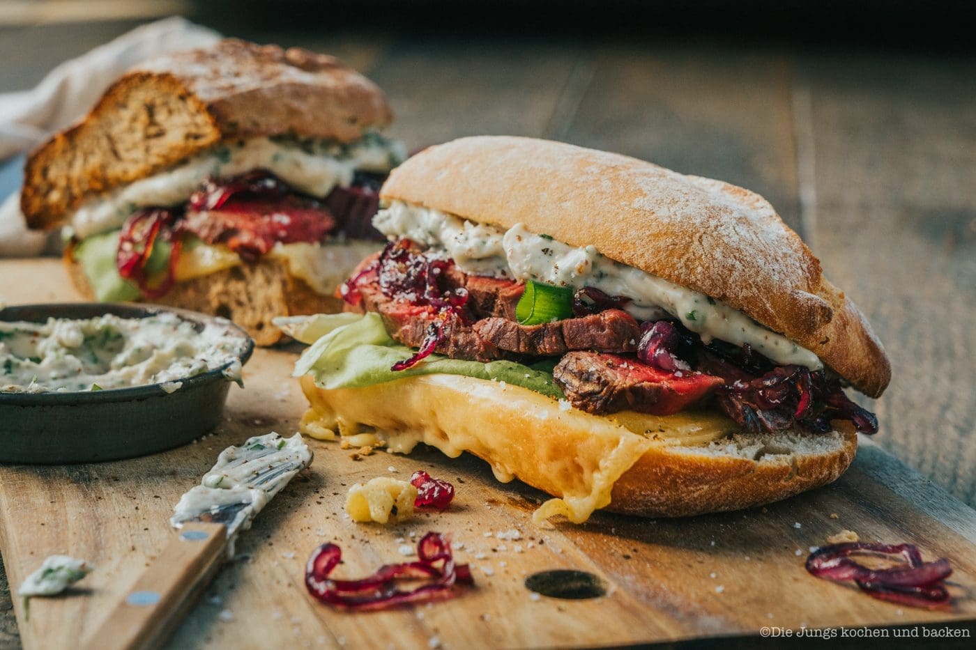 Steaksandwich 1 2 | Vor ein paar Tagen hat mich irgendwie der absolute Fleischhunger überfallen. Ganz plötzlich und unerwartet. Aber ich vermute, das lag an unseren Nachbarn, die fast jeden Tag ihren Grill angeworfen hatten und wir den lecker rauchigen Geruch schon mittags in der Nase hatten. Ich hatte aber überhaupt keine Lust, noch Beilagen, wie meinen Kartoffelsalat vorzubereiten und da kam ich darauf, ein saftiges Steaksandwich mit karamellisierten Zwiebeln zu machen. Denn da hat man ja alles in einem. Brot, Salat oder anderes Gemüse und leckeres gegrilltes Steak.