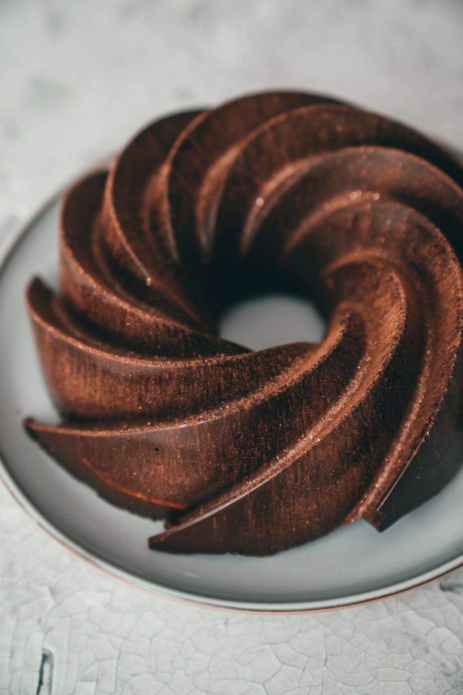 Zimt-Marmorkuchen mit Schokoglasur und Goldschimmer auf einem Teller
