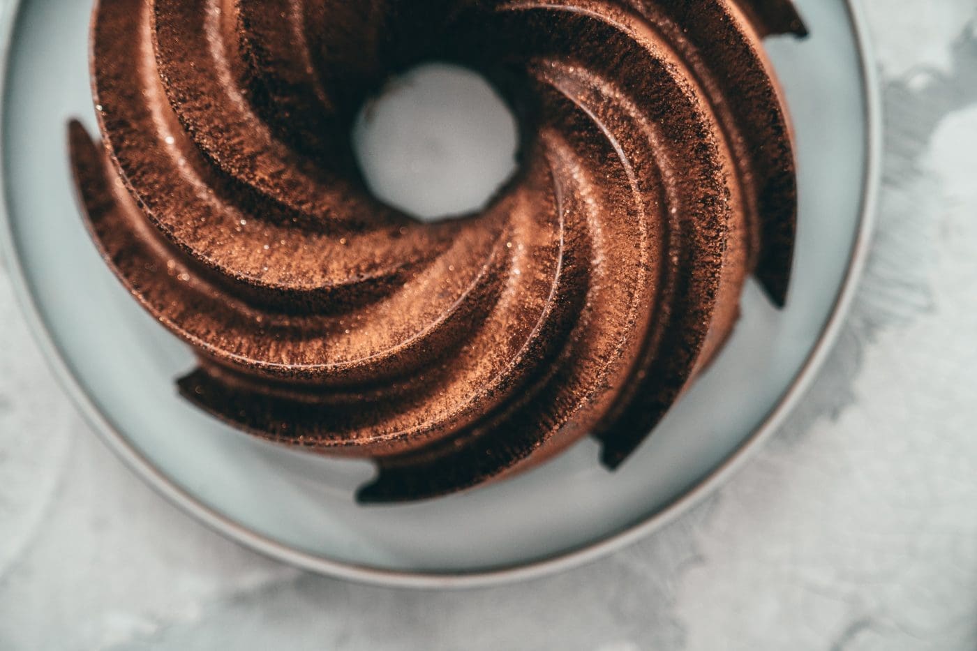 Glatte Schokoglasur aus der Silikonform mit allen Rillen des Gugelhupfs, von oben