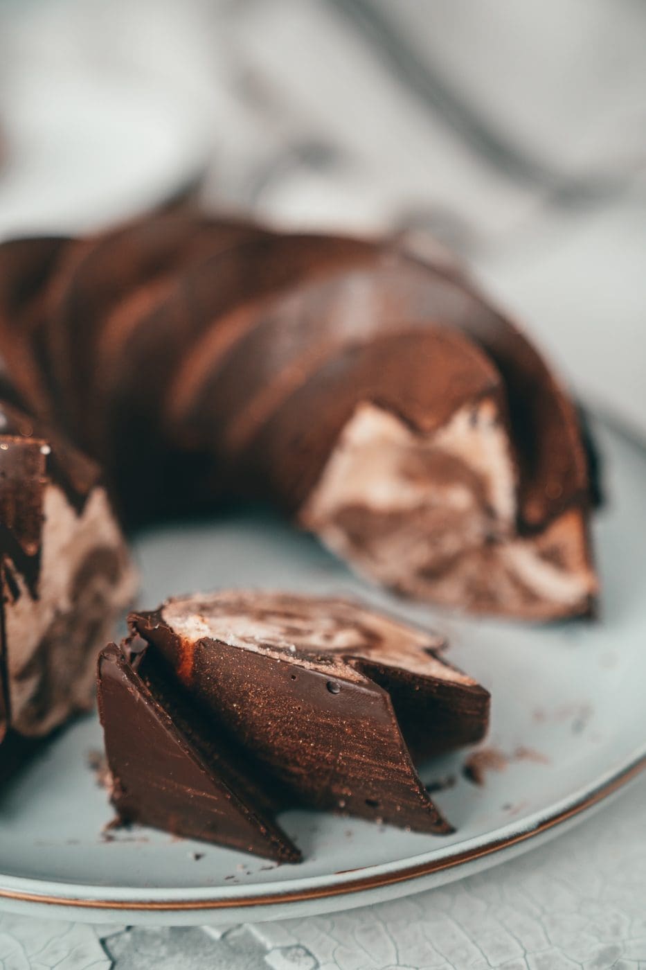 Kuchenstücke vom Zimt-Marmorkuchen vor dem angeschnittenen Gugelhupf