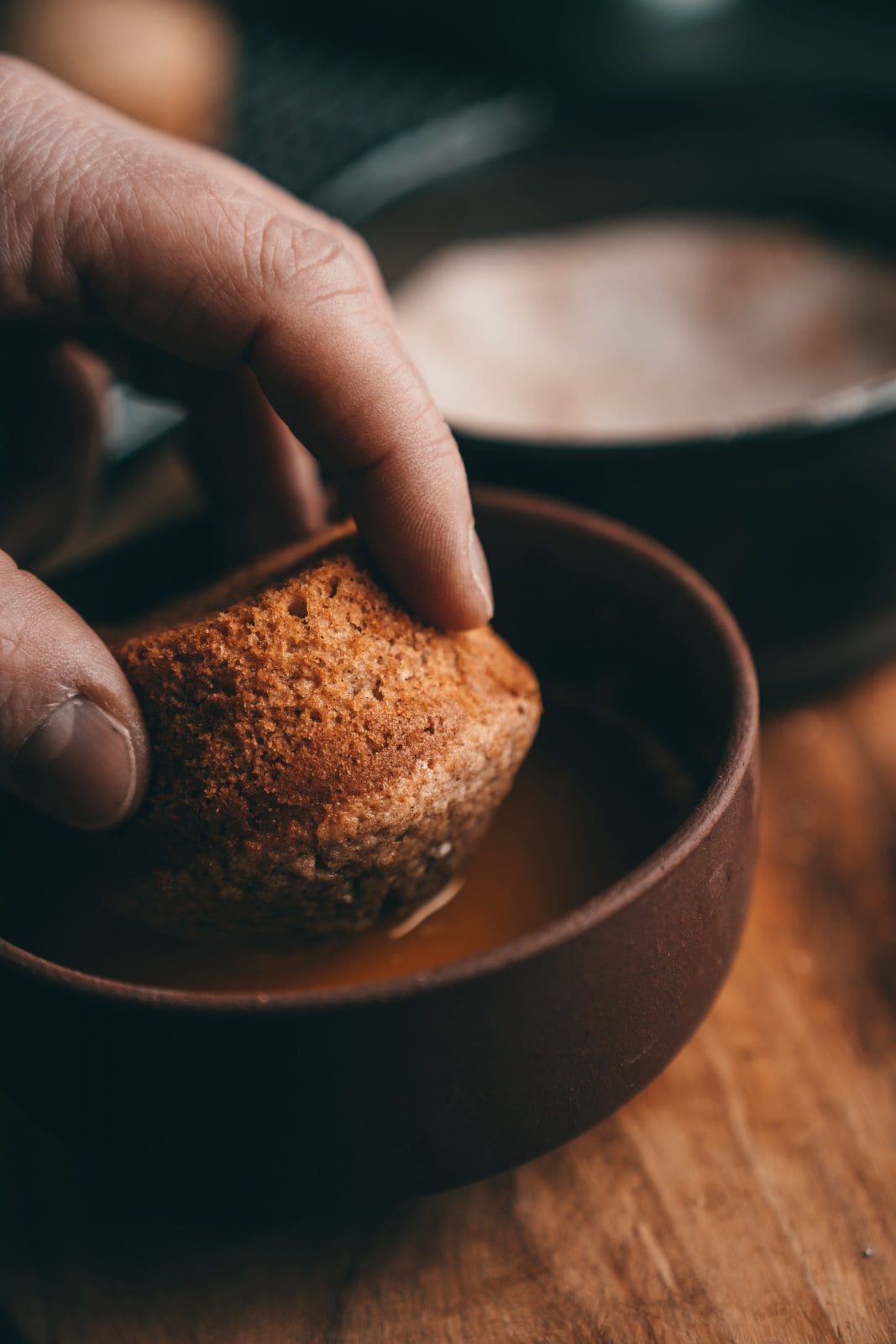 Warmer Muffin wird kopfüber in geschmolzene Butter getaucht