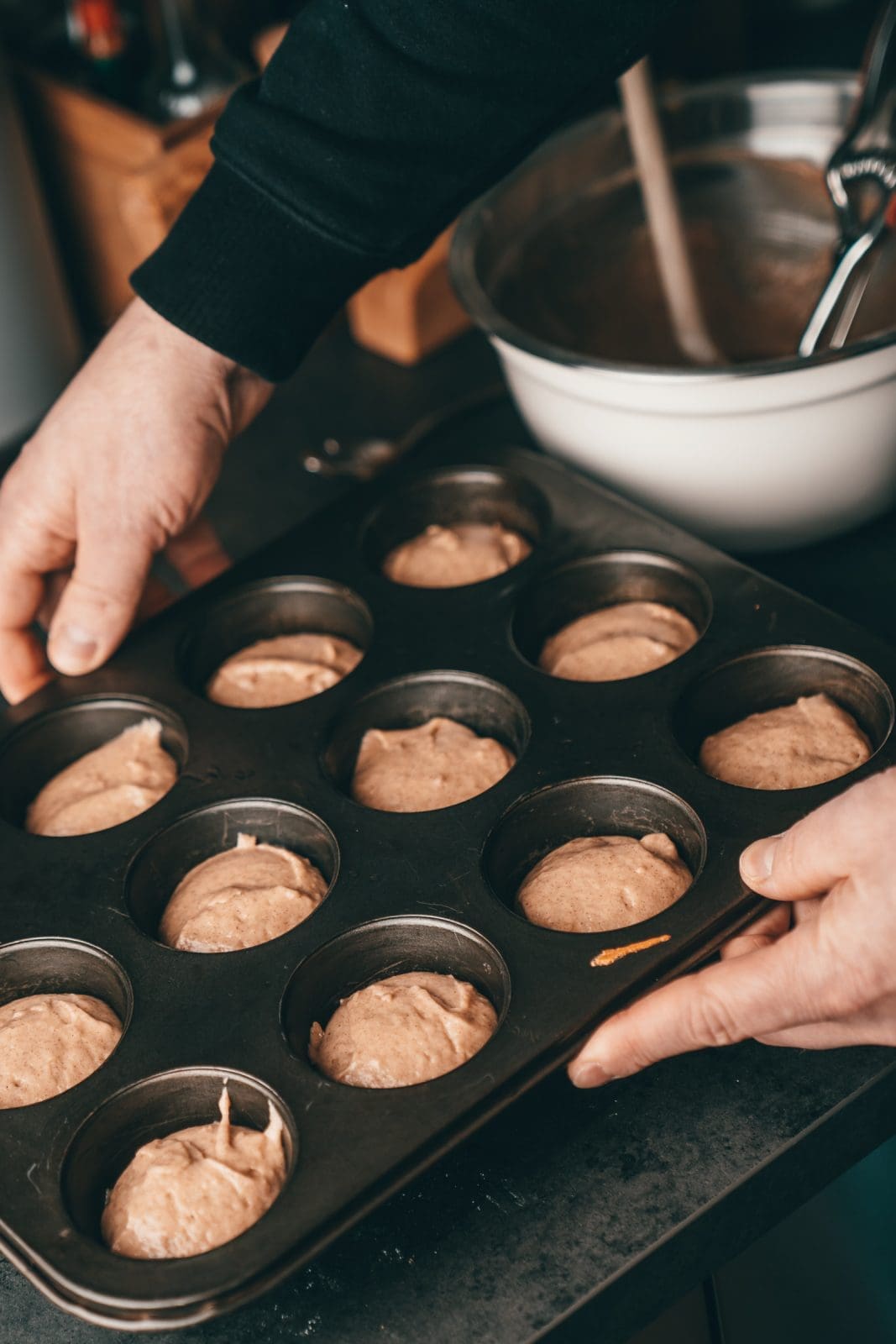 Muffinblech mit Teig für zwölf Zimt-Zucker-Muffins