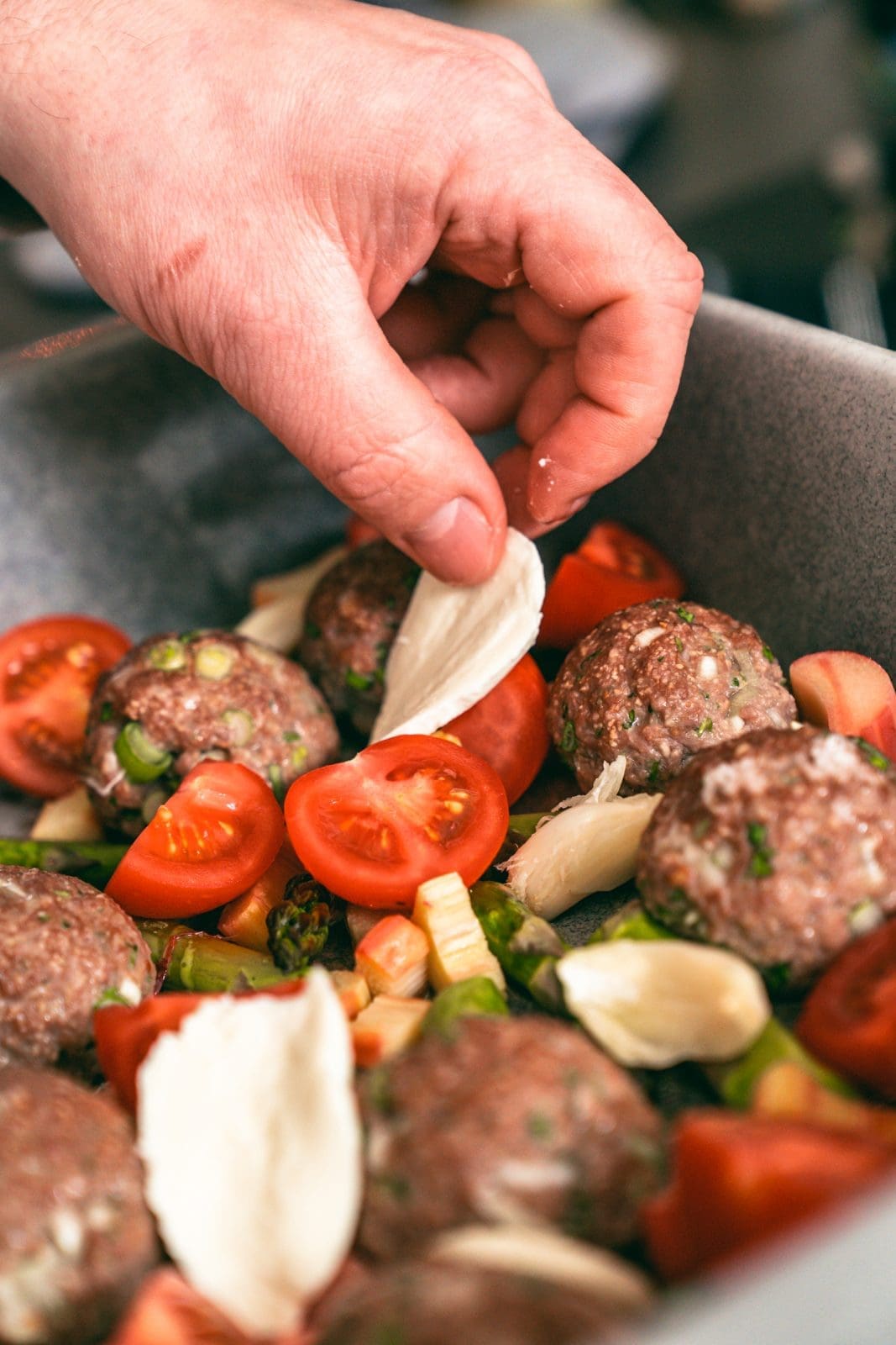 Auflaufform wird bestückt. Mozzarella in der Hand