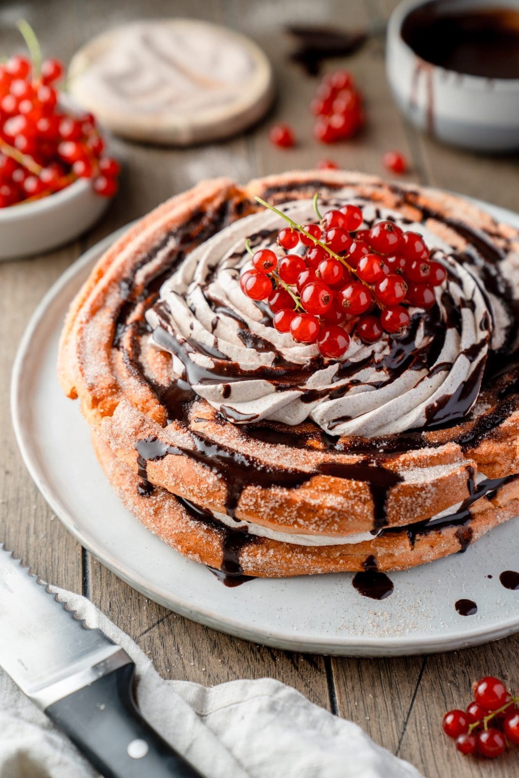Churros-Torte mit Zimtcreme, Schokosauce und roten Johannisbeeren