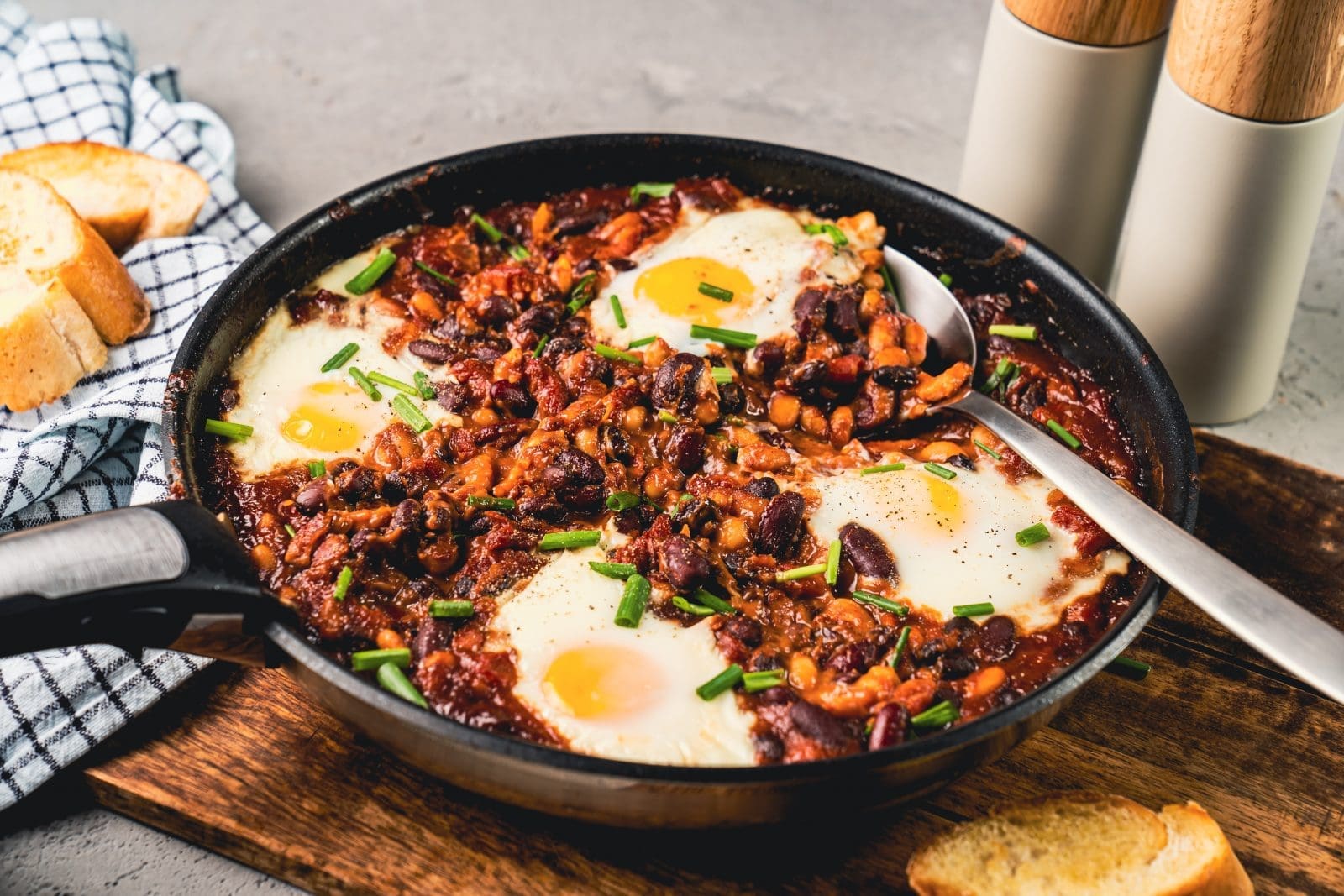 Feurige Baked Beans mit Ei - So geht Frühstück! 1 CKS04758 | Kennt ihr das Gefühl, wenn du morgens aufwachst und denkst: "Ich will gar nicht aus dem Bett, so gemütlich ist es"? Ja - wir auch. Aber meistens haben wir ein wenig mehr Motivation als faul im Bett liegen am Morgen. Manchmal steht ein eben auch eine Pfanne mit Bohnen auf dem Herd und wartet darauf, dass wir uns aufraffen und sie in ein tolles Frühstück verwandeln! Diese gebackenen Bohnen sind würzig und süß, mit ein paar Eiern als Eiweißquelle. Sie sind auch perfekt für einen Brunch. Und sie sind ein hervorragender Energielieferant, bevor du nach einer durchzechten Nacht nach Hause gehst: diese feurigen Baked Beans mit Ei!