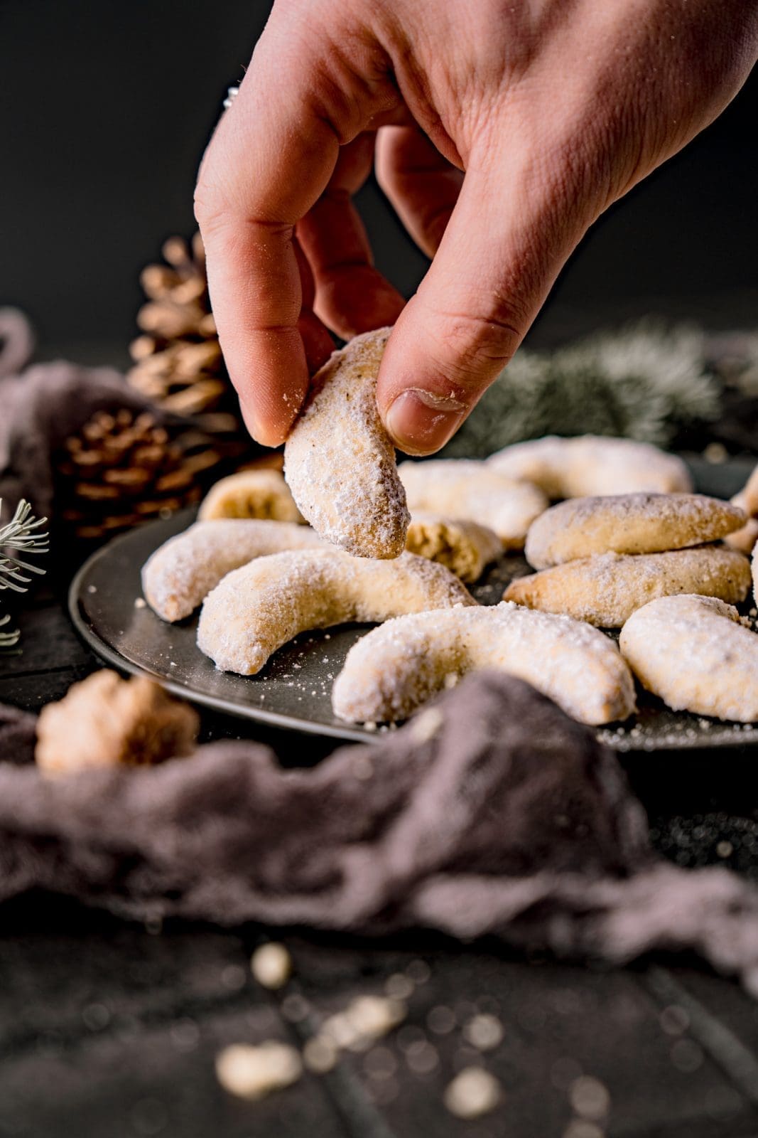 Vanillekipferl auf dunklem Teller – zart und mürbe, bestäubt mit Vanillezucke