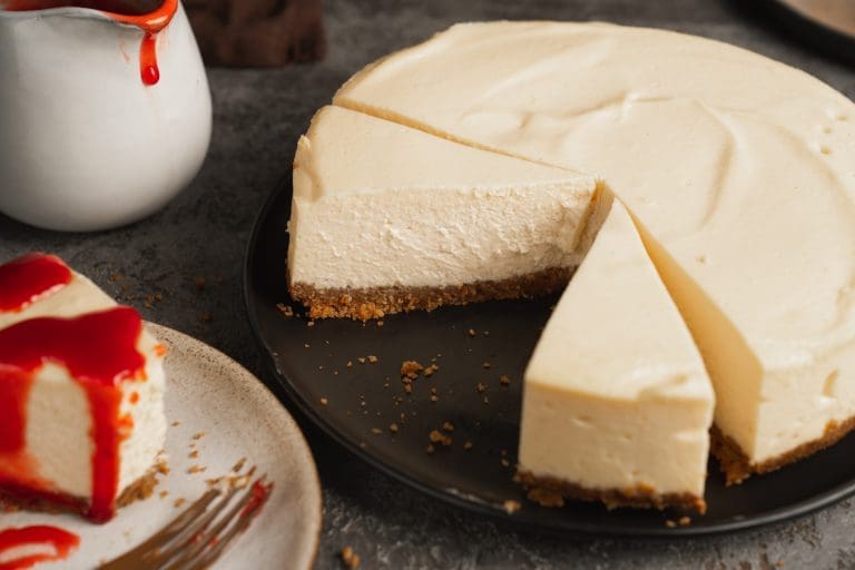 Käsekuchen. Klassisch mit Quark und Mürbeteig wie früher 7 New York Cheesecake angeschnitten, daneben ein Stück mit Erdbeersauce
