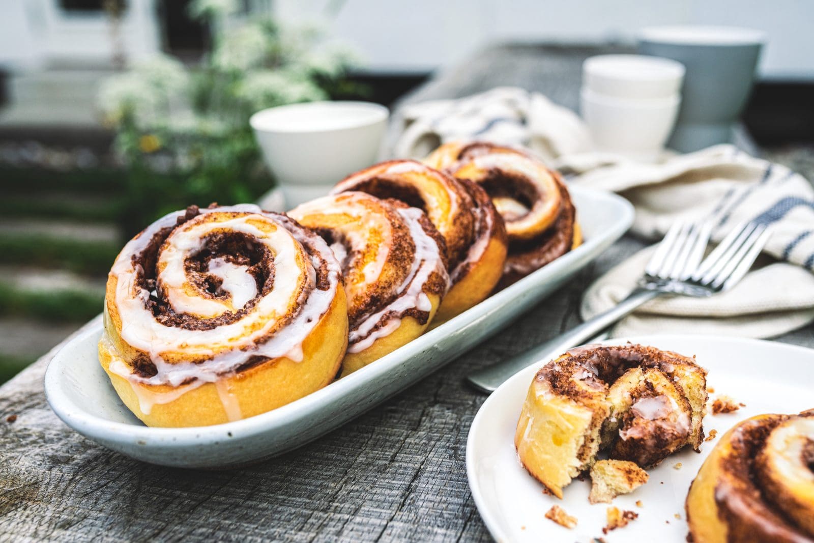 Zimtschnecken 17 | Gerade beim Schreiben unseres neuen Rezeptes sitze ich noch in unserem tollen Farmhaus in Dänemark. Und nebenbei backen im Ofen unsere Zimtschnecken, die wir Euch unbedingt zeigen müssen, damit Ihr sie nachbacken könnt. Ihr glaubt gar nicht, wie krass das ganze Haus nach Zimt riecht. Ich liebe den Geruch und kann kaum die Finger vom Ofen lassen und immer wieder nachschauen, ob sie vielleicht doch schon fertig sind, damit ich sie probieren kann. Normalerweise ist Sascha ja der Ungeduldige von uns beiden, aber bei süßen Schnecken aller Art kann ich mich auch nicht zurückhalten.