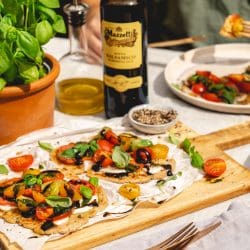 Caprese Flatbread Mazzetti 32 | Die Tomatenernte in den Gärten unserer Eltern lässt einfach nicht nach. Das ist natürlich gut so - heißt aber auch, sie müssen sich immer etwas Neues einfallen lassen, um nicht jeden Tag einen ganz normalen Tomatensalat zu essen. Den mögen wir alle sehr gerne, denn gerade mit frisch geernteten Tomate ist der nochmal so lecker. Aber trotzdem ist ein wenig Abwechslung immer gut. Und da wir beide uns gerade wieder ein schönes Rezept für unseren Partner Mazzetti L'Originale aus Modena überlegen durften, haben wir gleich an eine tolle Caprese Variante gedacht und sie auch direkt mal für unsere Eltern ausprobiert. Herausgekommen ist dieses Caprese Flatbread, bei dem der gute Balsamico eine wichtige Rolle spielt. Schnell zubereitet und unglaublich lecker - überzeugt Euch selbst!