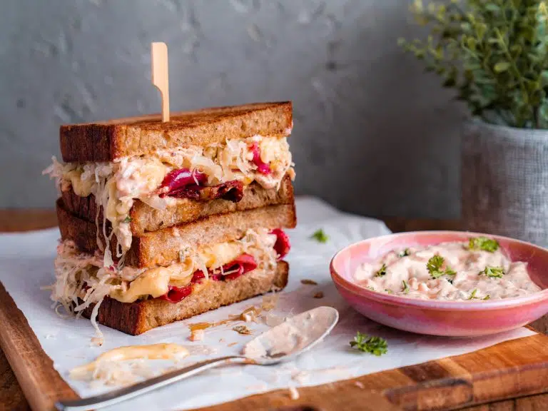 Steak Sandwich mit karamellisierten Zwiebeln und Petersilien-Mayo 13 Reuben Sandwich EDEKA 1 3 | Ein richtig gutes Steak Sandwich lebt von vier Dingen. Einem saftigen Hüftsteak, das medium rare vom Grill kommt und in dünnen Tranchen ins Brot wandert, süß-säuerlich karamellisierten roten Zwiebeln, einer cremigen Petersilien-Mayo und einem Ciabatta, das ihr kurz mit Cheddar auf dem Grill röstet. Mehr braucht es wirklich nicht! In rund einer halben Stunde steht unser Steak Sandwich auf dem Tisch, das Fleisch sollte vorher nur eine Stunde lang Zimmertemperatur annehmen.