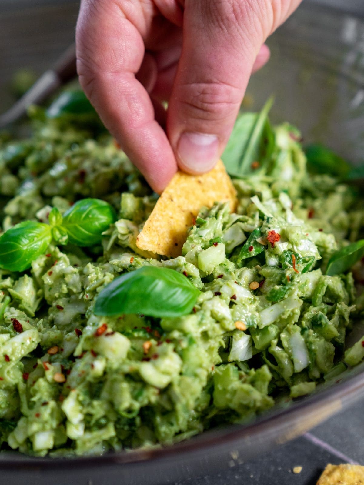Green Goddess Salat in der Schüssel. Es wird mit Nachos gedippt.