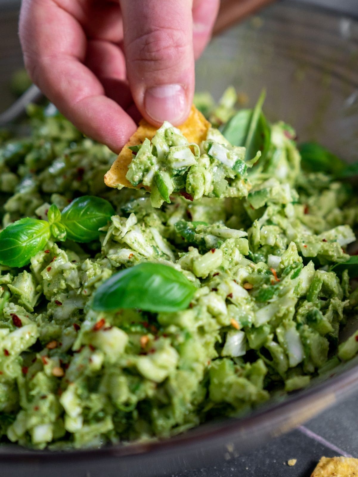 Green Goddess Salat in der Schüssel. Es wird mit Nachos gedippt.