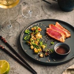 Miso-glasierter Thunfisch mit Gurkenscheiben und Jalapeños auf einem Teller