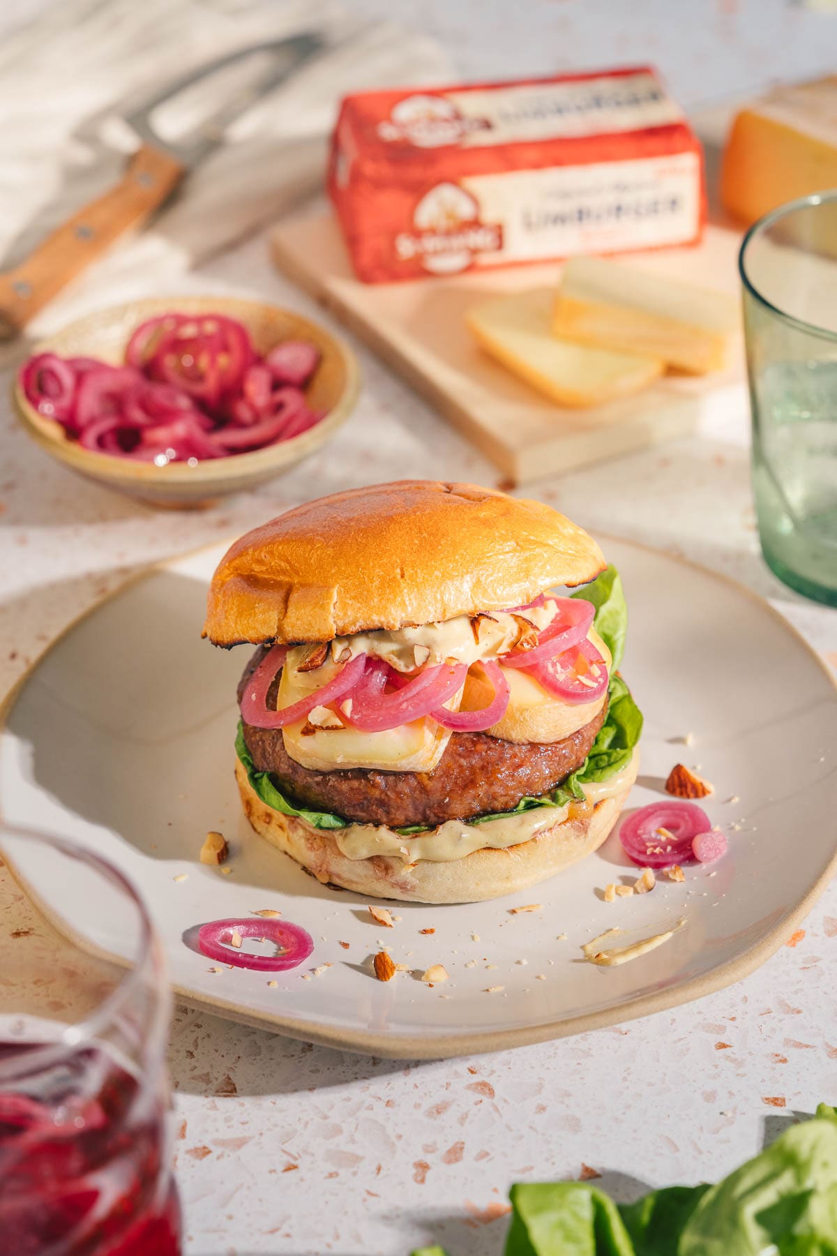Flambierter Limburger Burger zum BBQ Day: würzig, cremig, mit Pickled Onions & Honig-Senf-Sauce. Jetzt das Rezept entdecken & losgrillen!
