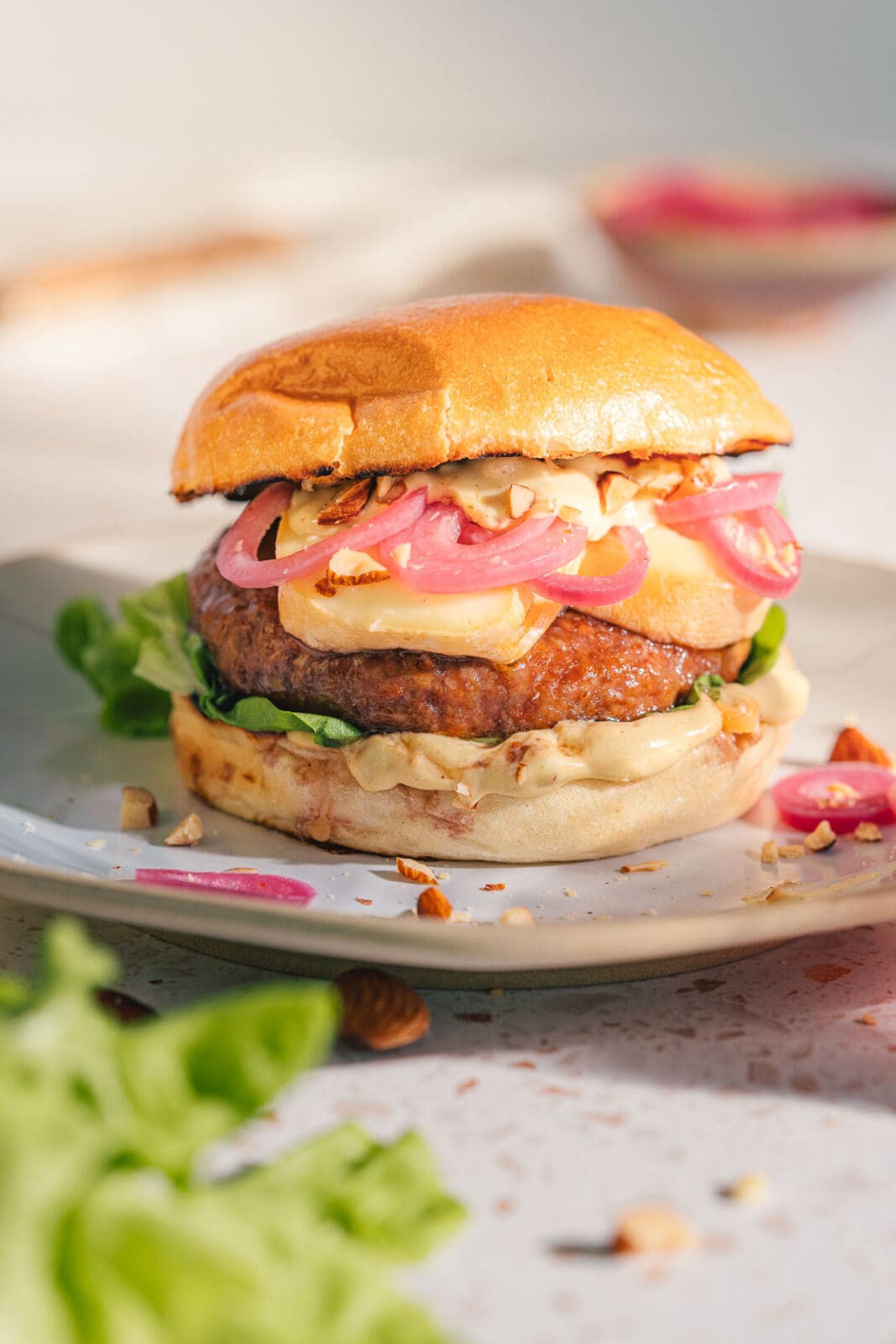 Flambierter Limburger Burger zum BBQ Day: würzig, cremig, mit Pickled Onions & Honig-Senf-Sauce. Jetzt das Rezept entdecken & losgrillen!
