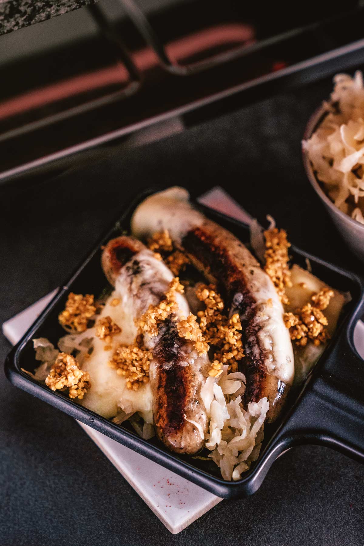 Raclette Pfännchen Ideen – Unsere liebsten Kombis von klassisch bis Tapas 4 Raclette Pfännchen Ideen mit Bratwurst, Sauerkraut, geschmolzenem Käse und Crunch Topping