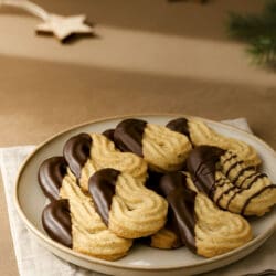 Schokoladenüberzogene Spritzgebäck mit Haselnüssen auf Teller