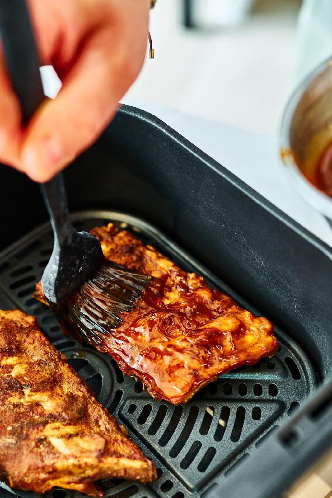 Spareribs werden in der Schublade vom Airfryer mit der Glasur eingestrichen