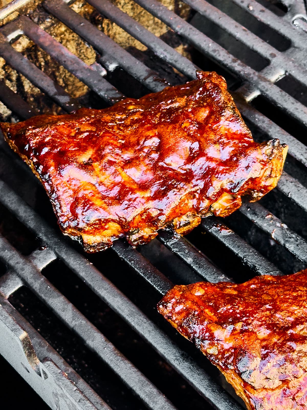 Mit der Glasur eingepinselte Spareribs auf dem Grillrost