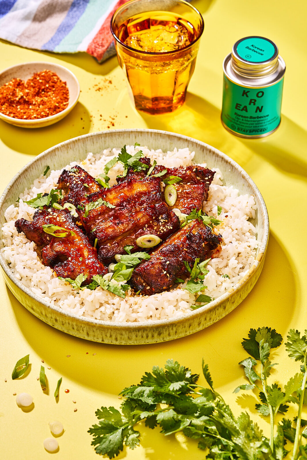 Koreanischer Schweinebauch aus dem Airfryer auf Reis mit Koriander und Frühlingszwiebeln, daneben Gochugaru
