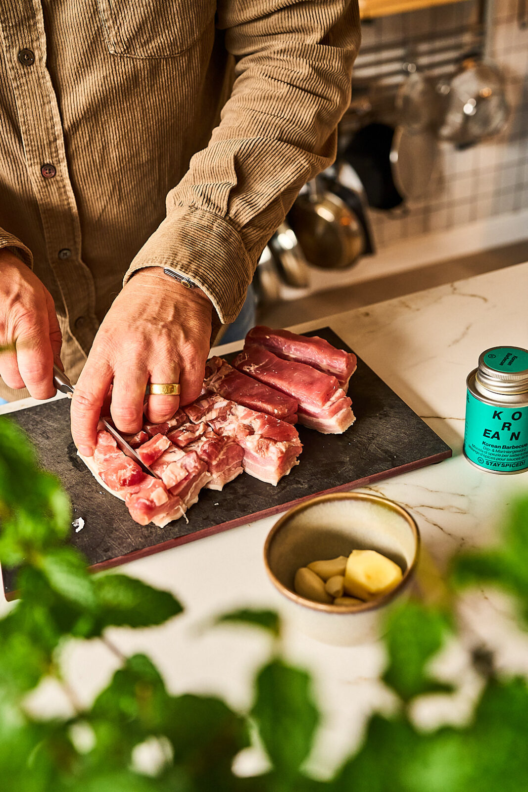 Schweinebauch in dicke Streifen schneiden für koreanischen Schweinebauch, daneben das Korean BBQ Gewürz von Stay Spiced!