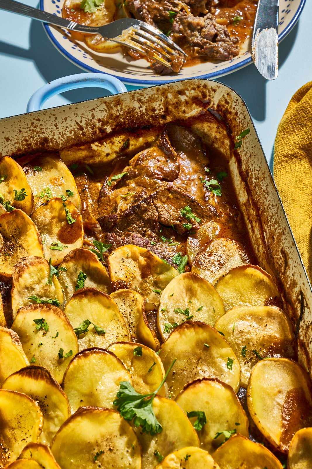 Knusprig gebackene Kartoffeldecke am Rand der Auflaufform mit dem Fleisch darunter