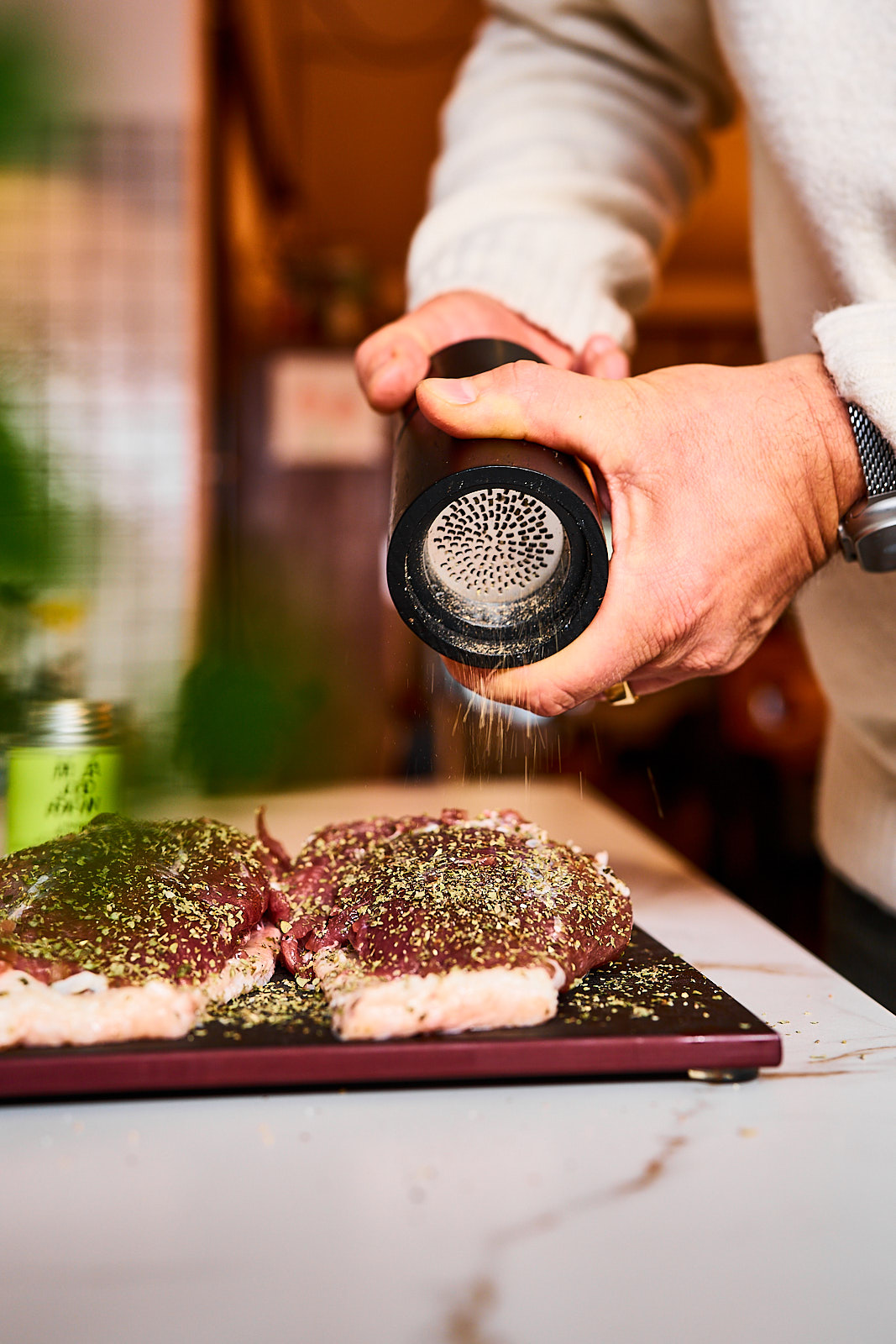 Rohe gewürzte Gänsebrust wird mit Pfeffer aus der Mühle gewürzt
