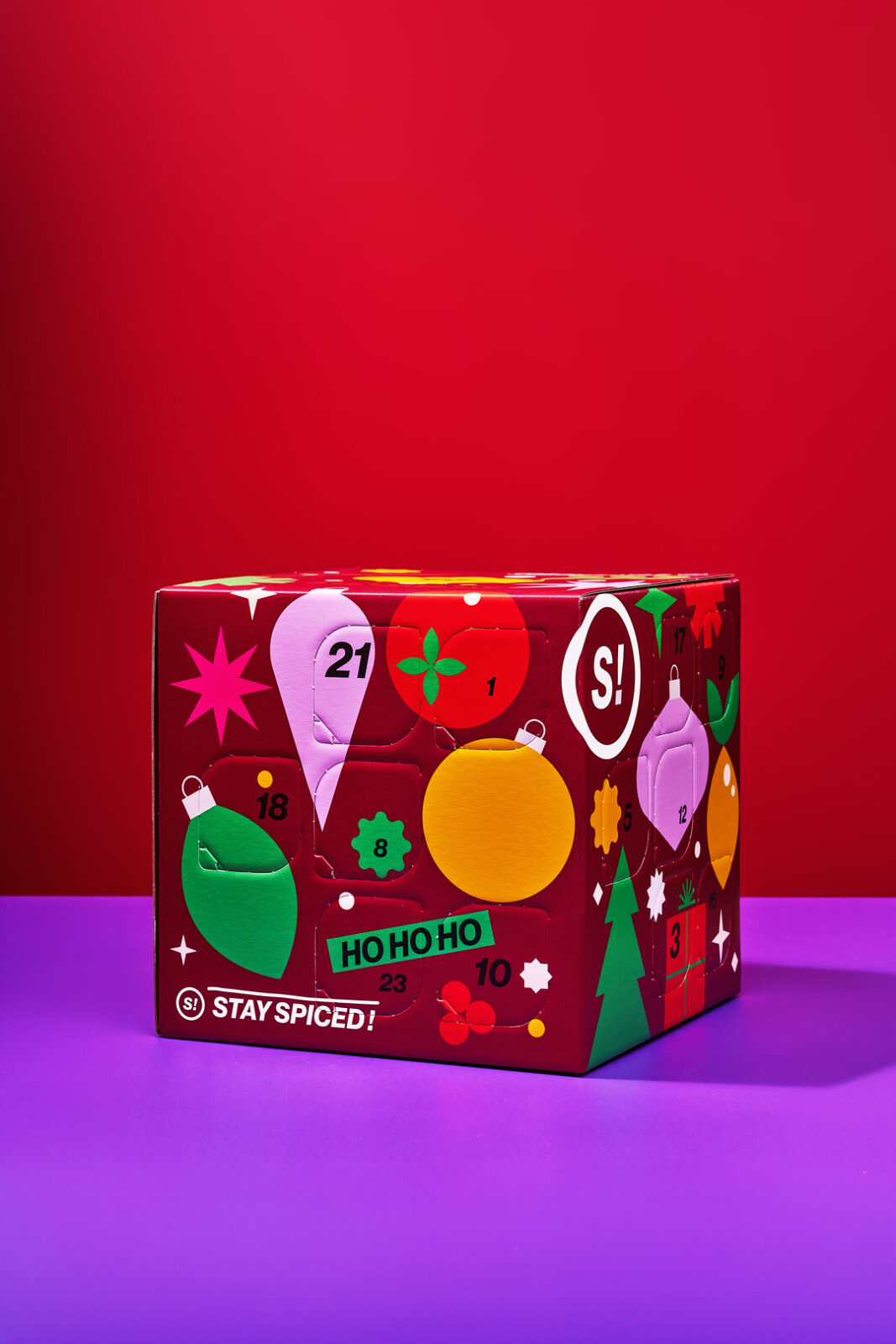 Pumpkin Spice Rezepte aus dem Adventskalender. Latte, Porridge und Kürbis-Muffins 2 Der rote STAY SPICED ! Spice Cube Deluxe Gewürz-Adventskalender 2026 vor rotem Hintergrund
